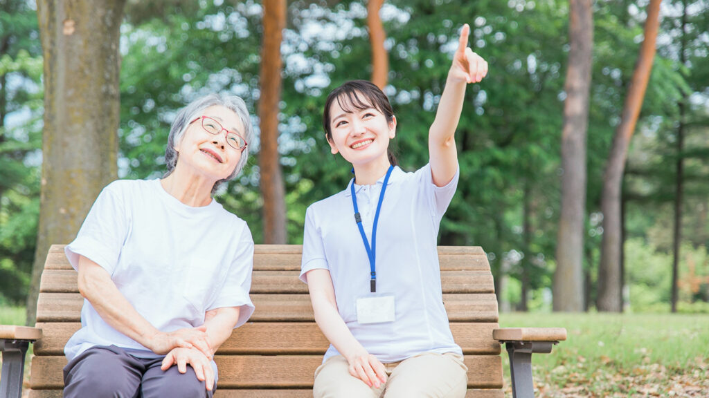空を指差す介護士と女性利用者