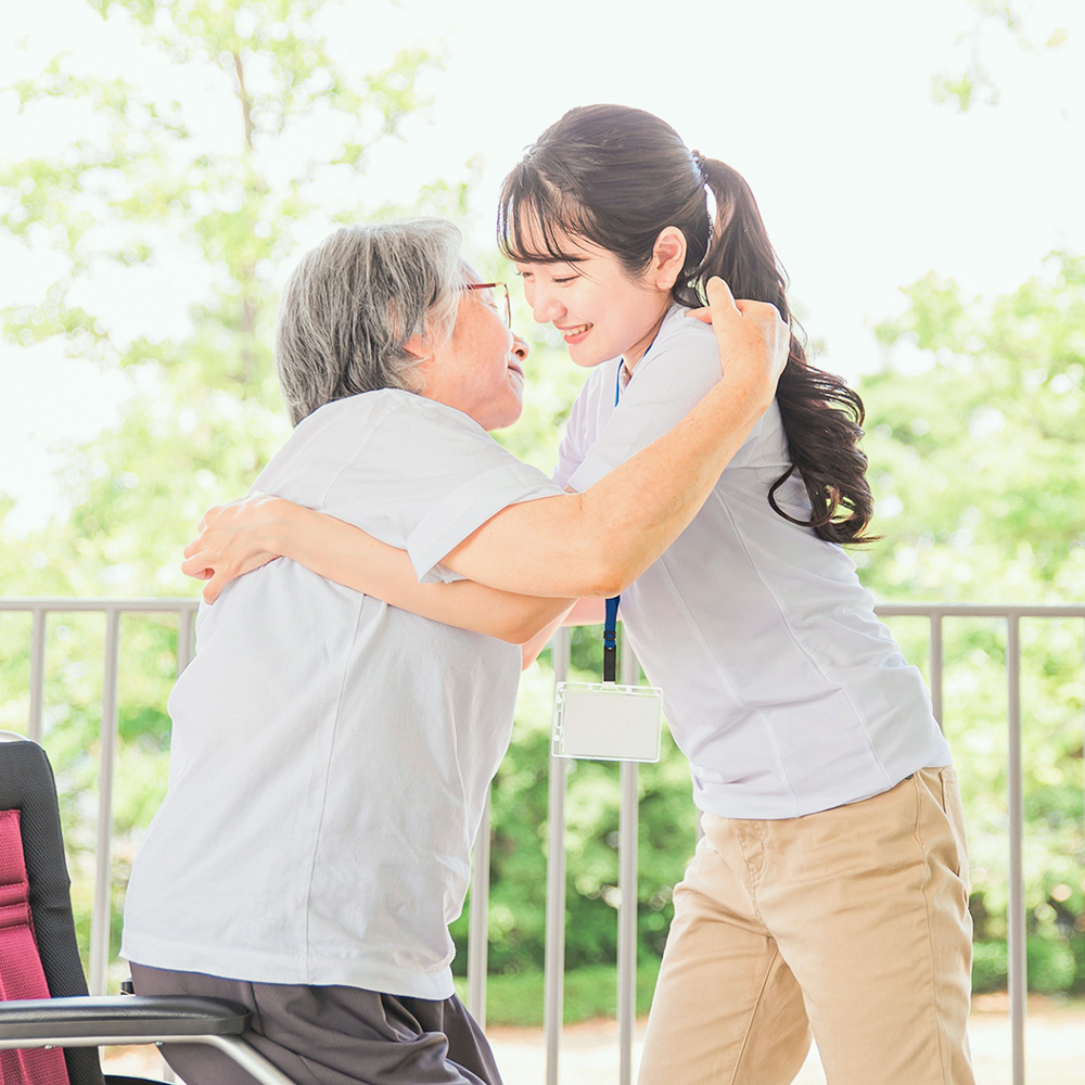 車椅子の女性を支えるスタッフ