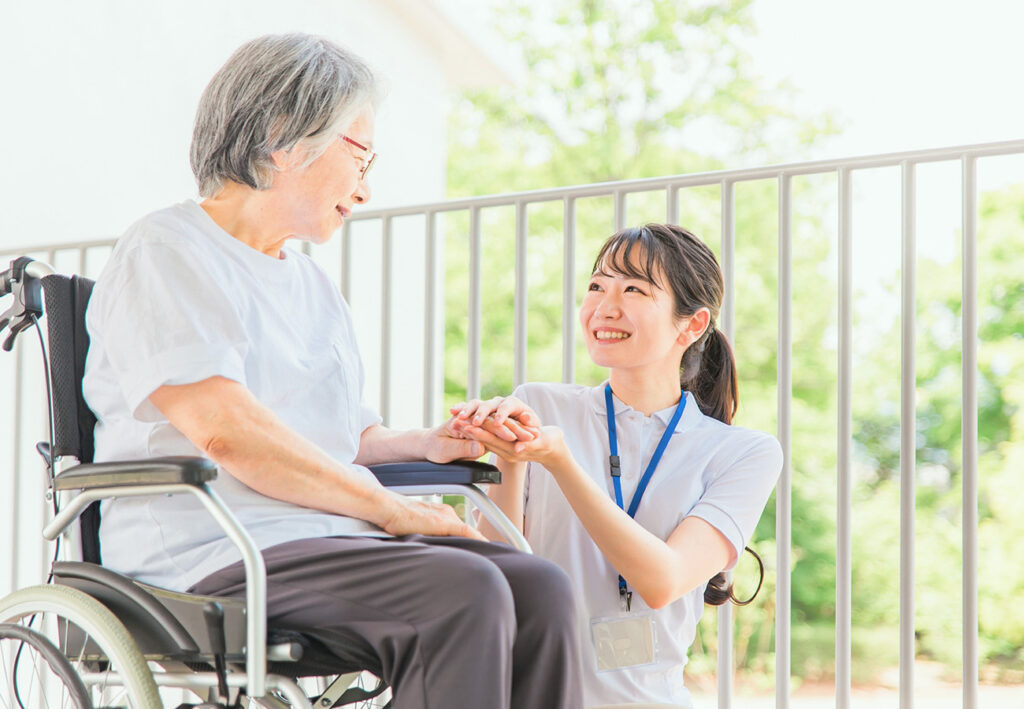 笑顔で女性の手を握るスタッフ